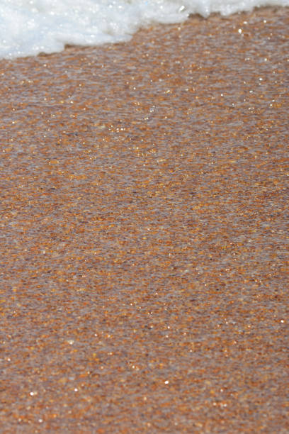 recuo de águas claras sobre areia shell como uma onda vem em - receeding - fotografias e filmes do acervo
