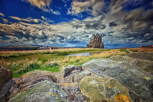 Whitby Abbey ruins with a blue sky with fluffy white cumulus clouds in the background.