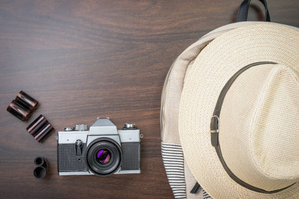istock Camera, film reel, hat and backpack  on wooden background. 820438642