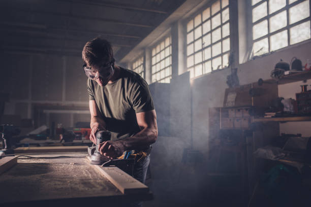 istock Male carpenter using sander on a piece of wood in a carpentry workshop. 820447984