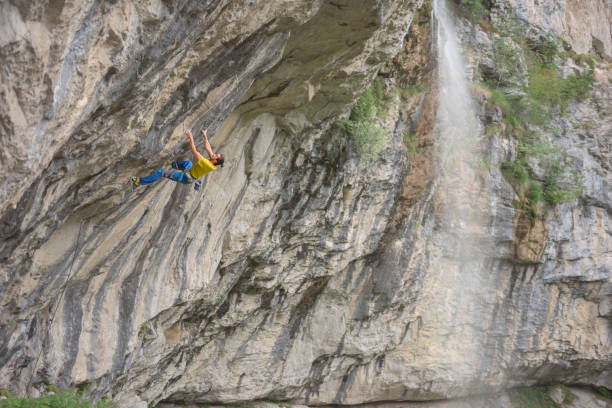 istock Determined male rock climber ascending on steep craggy rock wall 820461278