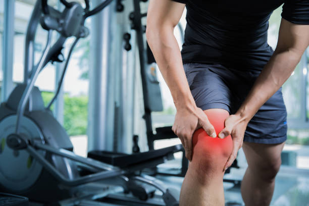 Healthy men Injury from exercise in the gym, he injured his knee stock photo