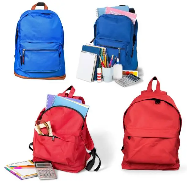 Backpack with school supplies on background