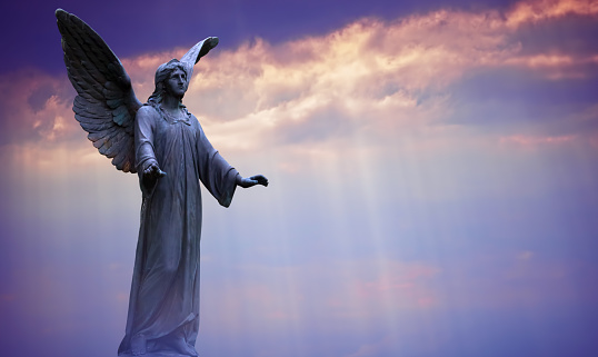 Angel sculpture on beautiful sky background concept of Religion