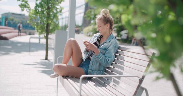 istock Young caucasian woman using phone in a city park. 820487010