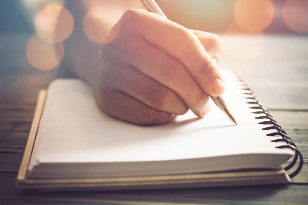 istock hand of people, student writing and note on notebook on wood table with copy space, in library, concept as education attempt and make effort to win, intend to improve knowledge for future life 820487664