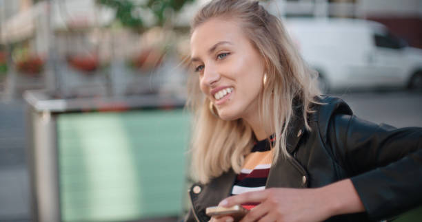 istock Young caucasian woman using phone in a city. 820490792