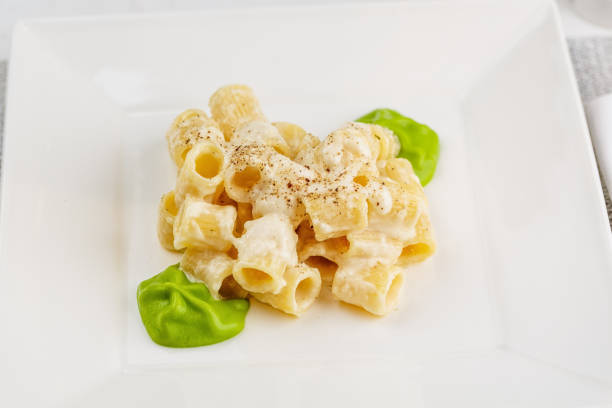 Penne pasta with a creamy sauce with parmesan cheese and spinach sause