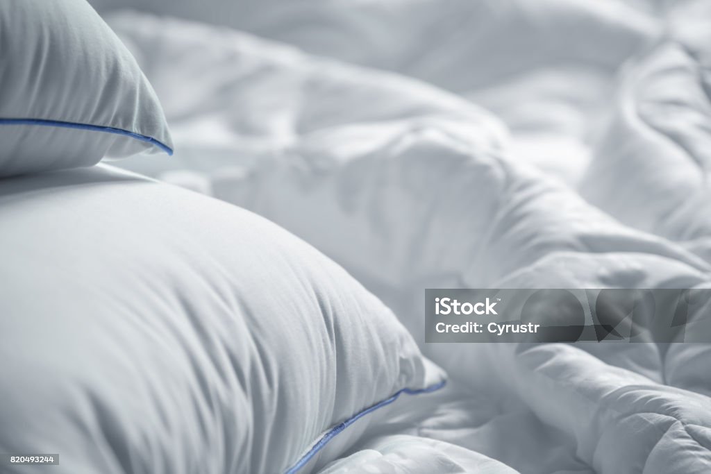 White pillows and blanket. Wrinkle messy blanket  in bedroom after waking up in the morning. Bed details. Duvet and blanket, an unmade bed in hotel bedroom with white blanket. Messy White Bed. Pillow Stock Photo