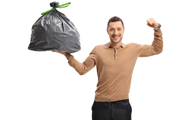 istock Young man holding a garbage bag and flexing his biceps 820504230