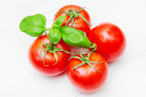 group of fresh resd tomatoes with basil