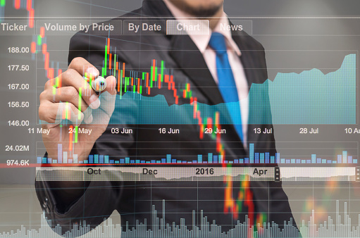 businessman drawing the stock graph with stock market exchange over the trading room , business marketing concept