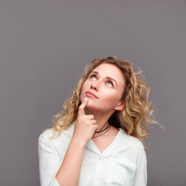 istock Blonde woman looking up touching chin 820519752