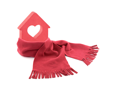Small red house with heart wrapped in a scarf isolated on white