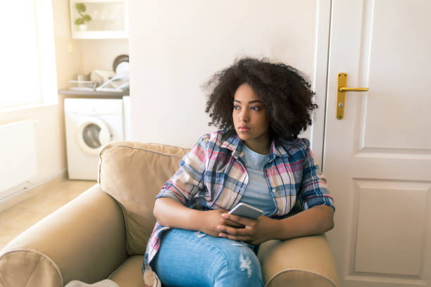 istock Sad woman sitting alone at home 820538848