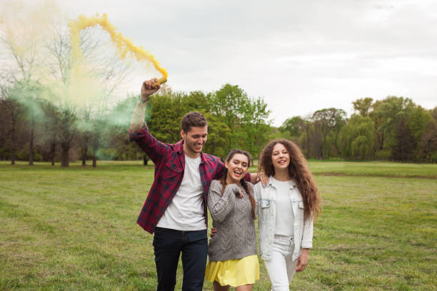 istock Guy and girls walking with smoke flare 820551910