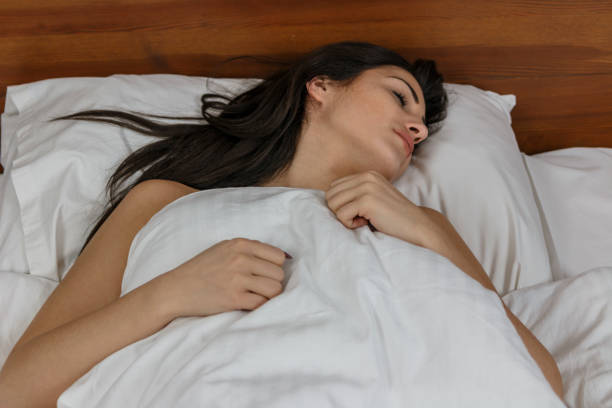 istock Pretty woman sleeping in bed 820557360