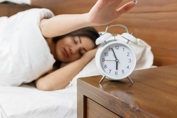 istock Young sleeping woman and alarm clock in bed 820570128