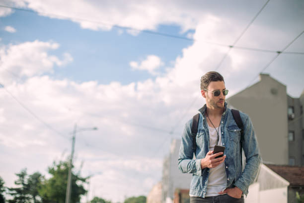 istock Man on the street holding phone 820575536