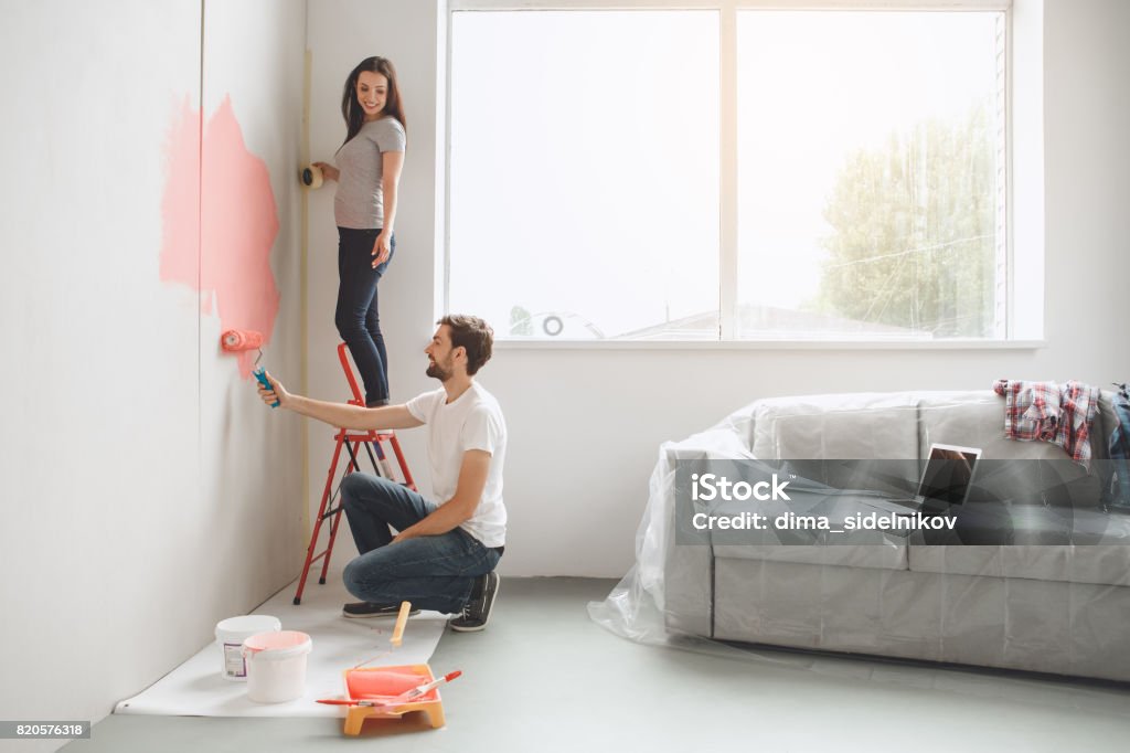 Jeune couple faisant appartement ensemble se réparent - Photo de Peindre libre de droits