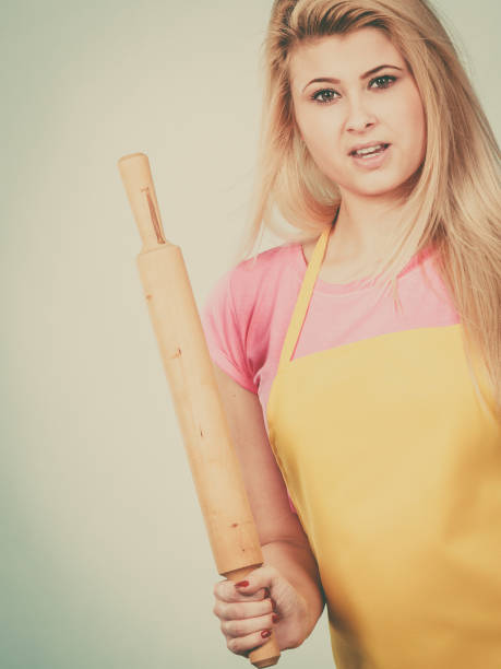 istock Woman wearing apron holding rolling pin 820576506