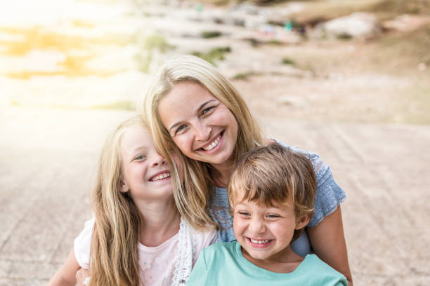 istock mother, son and daughter cuddling on the beach 820576746
