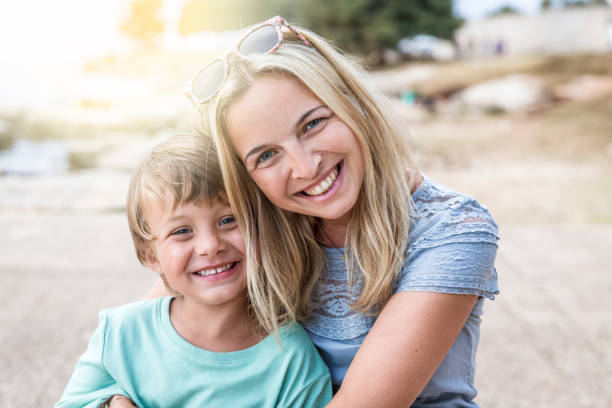 istock mother and son cuddling on the beach 820576764