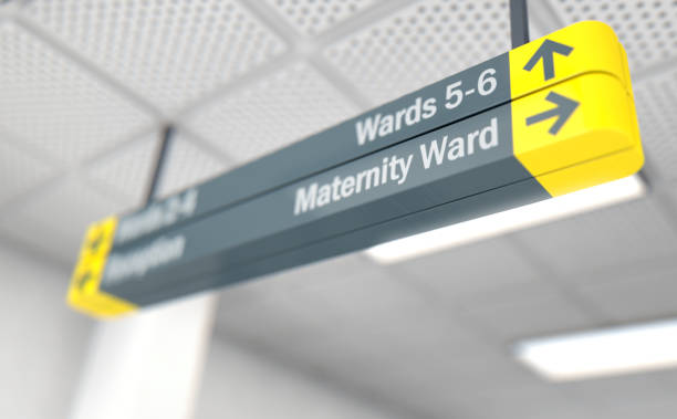 Hospital sign MATERNITY A ceiling mounted hospital directional sign highlighting the way towards the maternity, ward - 3D render hospital room stock pictures, royalty-free photos & images