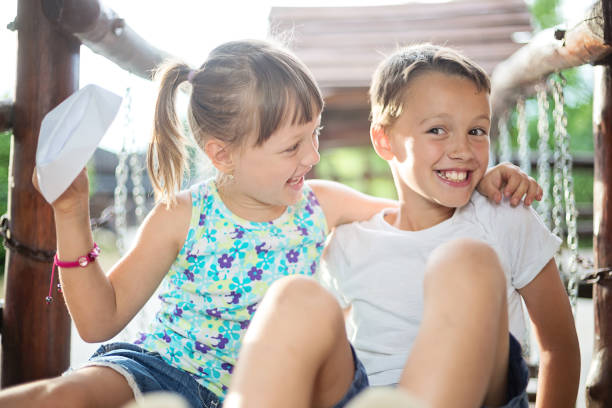 istock Two happy siblings sitting and hugging outdoors 820582780