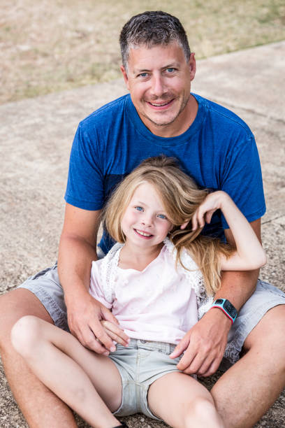istock Father and daughter cuddling on the beach 820583424