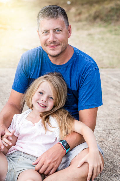 istock Father and daughter cuddling on the beach 820583464