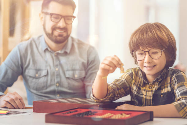 istock Delighted intelligent boy holding a chess piece 820584590