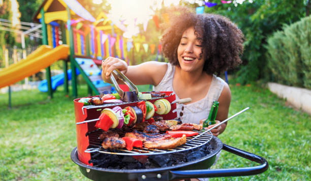 istock Smiling woman preparing barbecue at backyard 820584826