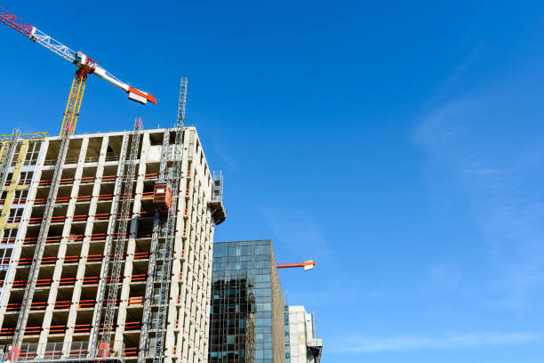 istock Two concrete buildings under construction and glass building with two tower cranes 820615248