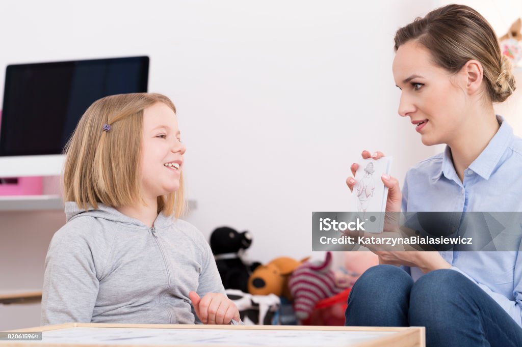 Discussing drawing during play therapy Child counselor discussing drawing with smiling girl during play therapy Child Stock Photo