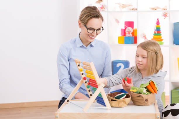 istock Tutor and girl counting with abacus 820615972