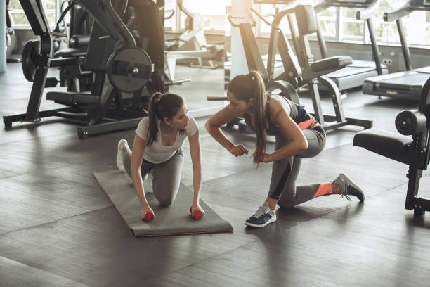 istock Young women exercise together in the gym 820619042