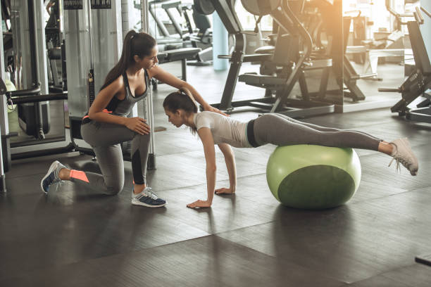 istock Young women exercise together in the gym 820625400