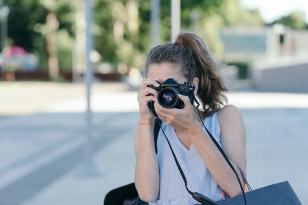 istock Young woman photographing with vintage camera 820659982