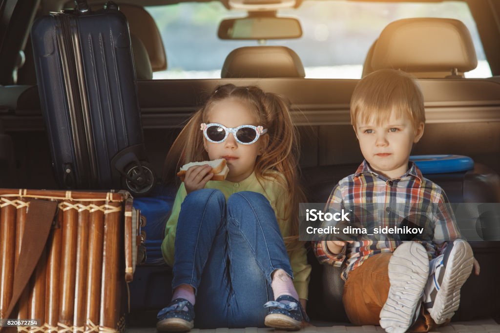 Travel by car family trip together vacation Travel by car family together brother and sister sitting in a trunk Car Stock Photo