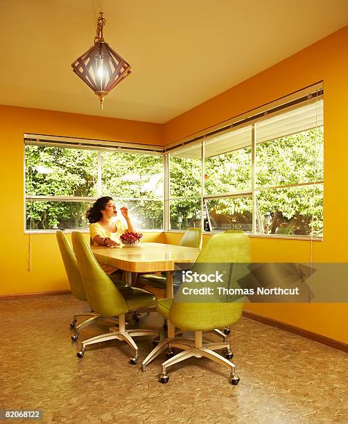 Woman Eating Cherries In Dining Room Stock Photo - Download Image Now - Yellow, Cherry, Eating