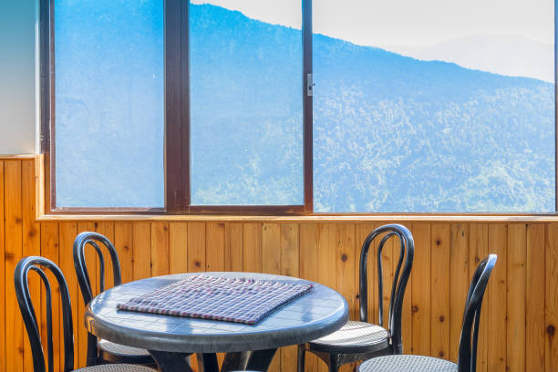 istock Table, chairs and window with view of mountain outside. 820699604