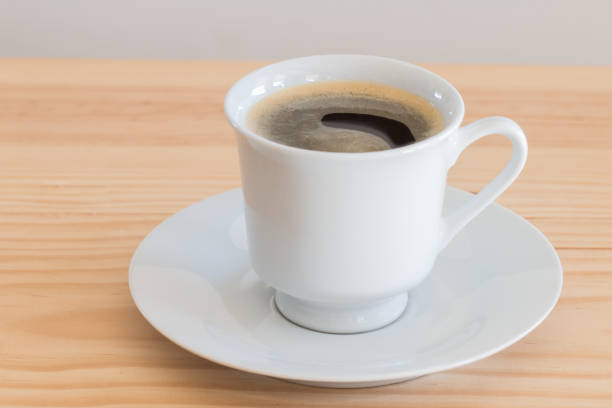 istock Cup of coffee on wooden table, close up. 820720420
