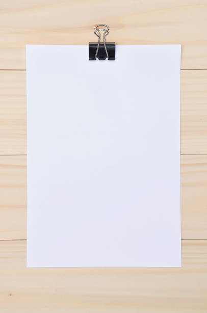 istock Black clip and white blank paper on wooden background 820721238