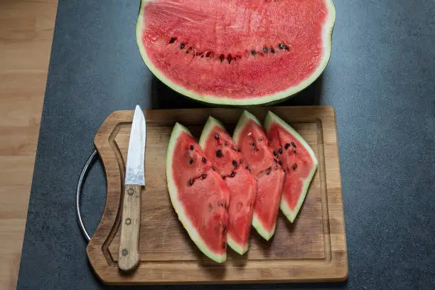 Half watermelon with slices on the wooden board