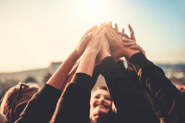 Group of Teenagers Volunteer with Raised Hands to the Sky Group of Teenagers Volunteer with Raised Hands to the Sky hands clasped stock pictures, royalty-free photos & images