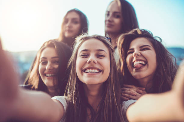 Group of Crazy Girls Taking Selfie and Making Faces Outdoors Group of Crazy Girls Taking Selfie and Making Faces Outdoors selfie girl stock pictures, royalty-free photos & images