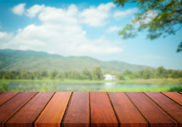 istock Selected focus empty brown wooden table and blue sky or mountain blur background with bokeh image. for your photomontage or product display. 820741584