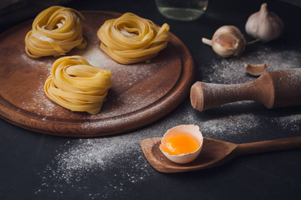 istock Raw homemade pasta with flour and spices on the rustic background. 820762218
