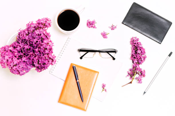 istock Workplace with cup coffee dairy pen pencil glasses lilac flowers 820765544